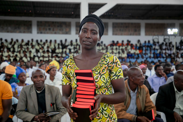 Woman holding a stack of Bibles.